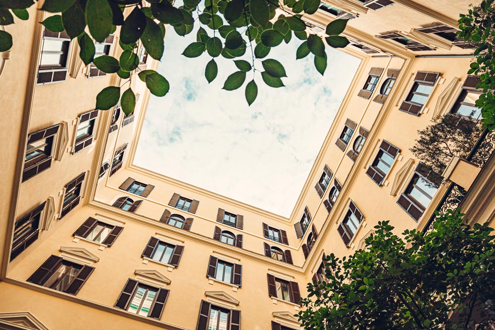 Fasad av gula lägenheter från en innergård