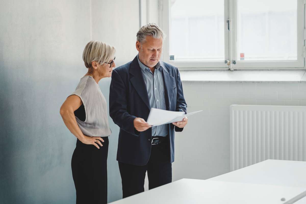 En man och en kvinna står och går igenom ett dokument